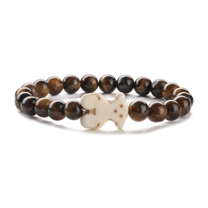 Bracciale elastico in occhio di tigre con ciondolo animale intagliato bianco su sfondo bianco