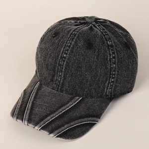 Detail of dark gray washed denim baseball cap with vintage distressed texture and stitching