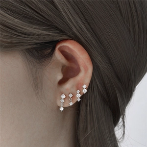 Close-up of 925 sterling silver stud earrings set with sparkling cubic zirconia on ear