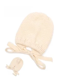 Detail view of beige knit hat with earflaps and straps showing soft texture and back