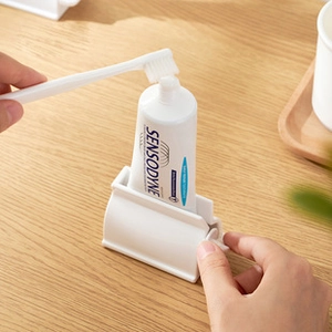 Vue détaillée d'un presse-dentifrice manuel blanc avec bouton rotatif sur bois