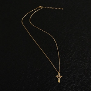 Detailed macro view of the gold cross necklace with a zircon-inlaid heart pendant