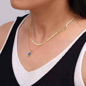 Double-layered 18K gold plated necklace with blue lapis lazuli pendant on a model