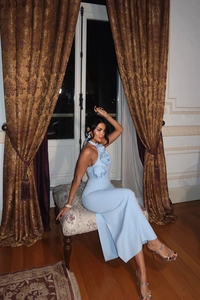 Close-up of light blue halter evening dress featuring 3D floral accents and side slit