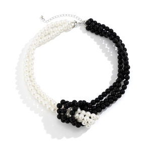 Detailed view of layered faux pearl choker with black and white beads and knot accent