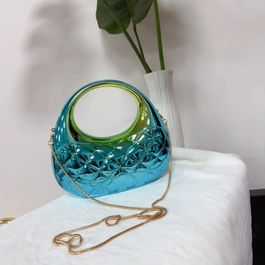 Détail d'une pochette bleu métallisé avec texture matelassée et chaîne dorée élégante