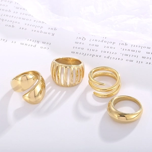 Detailed close-up of a four-piece gold minimalist ring set with hollow and spiral designs