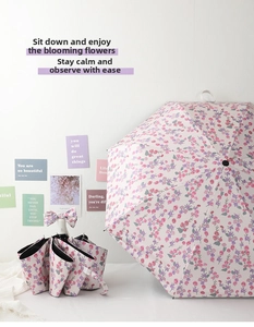 Detail of floral folding umbrella with pink flower pattern and bow tie handle