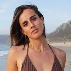 Close-up of beach theme necklace with seashell starfish pendants and gold starfish earrings