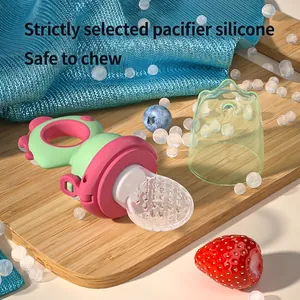 Dinosaur baby fruit feeder with pink silicone mesh on a rustic tray with berries