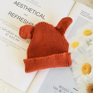 Detail of orange knit beanie with cute ears for 20cm plush doll on aesthetic background