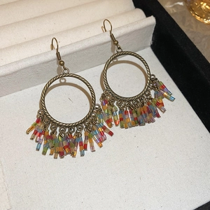 Detail of bohemian tassel earrings with colorful beads and antique bronze rings