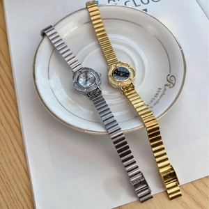 Vintage gold and silver quartz watches with flower case on white ceramic plate