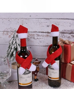 Close-up of red and white mini Christmas hats and scarves set for wine bottle decoration