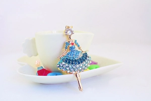 Macro shot of gold ballerina pendant with blue and clear crystals for handbag