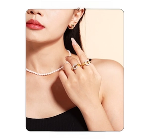 Close-up of elegant 18k gold plated ring set with sparkling crystals and pearl necklace