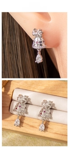 Detail of bell drop earrings with bow and crystals shown in gift box and worn