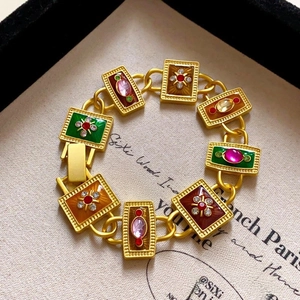 Detailed macro view of vintage gold bracelet with colorful enamel inlay and zircons
