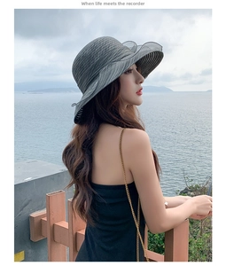 Detail of elegant dark grey sun hat with layered ruffle trim on the brim for beach