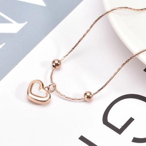 Minimalist rose gold heart necklace featuring a shell inlay pendant and beads