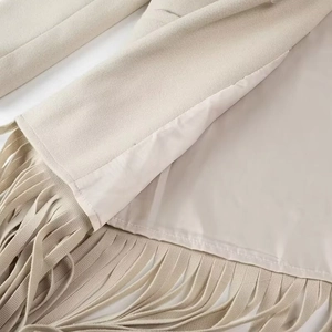 Détail du tissu en daim beige et de l'ourlet à franges de la robe trench élégante