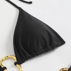 Detail of black bikini top with pleated edges and elegant gold metal ring accents
