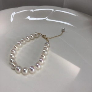 Detail of high luster white pearls on s925 silver bracelet with adjustable 14k gold clasp