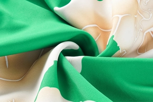 Close-up of green and white floral print fabric with ruffled layers and textured stitching