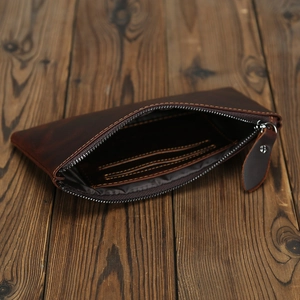 Macro detail of dark brown leather wallet showing zipper closure and internal card slots
