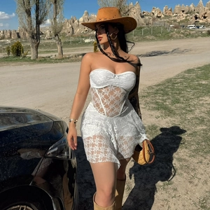 Detail of white lace corset dress with sheer mesh and ruffled hem for summer vacation