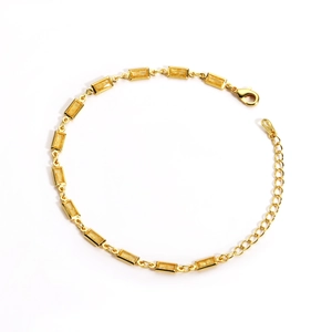 Détail d'un bracelet doré avec cristaux jaunes rectangulaires et fermoir mousqueton réglable