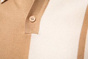 Close-up of knit fabric texture with beige stripes and button detail on polo shirt