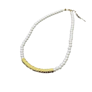 Elegant French style pearl necklace with gold textured metal tube on white background