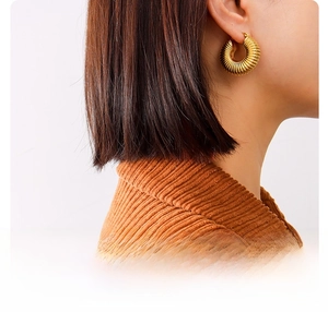 Close-up of 18k gold plated titanium steel hoop earrings with ribbed spiral texture