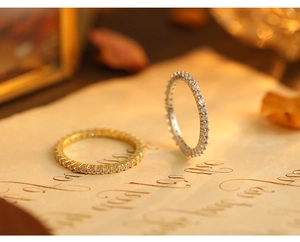 Close-up of gold and silver S925 sterling silver eternity rings with full pave diamonds
