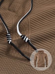 Close-up of brown men's hoodie featuring V-knit texture fabric and woven drawstrings
