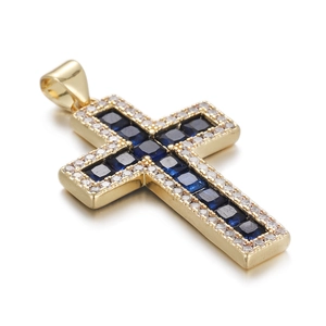 Macro detail of gold cross pendant with blue square stone and sparkling zircon border