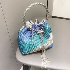 Dettaglio della borsa a secchiello in strass sfumati con manico ad anello e frange metalliche