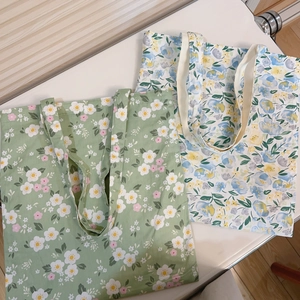 Detailed flat lay of floral print canvas tote bags in green and white textile options