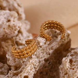 Détail macro du耳夹 en plaqué or 18 carats avec texture à trois rangées de billes
