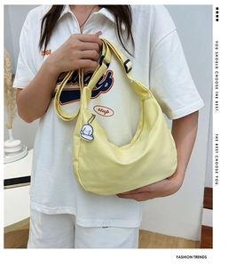 Light yellow canvas hobo bag with adjustable strap and cute dog pendant accessory
