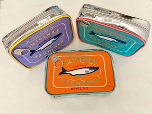 Detailed embroidery on sardine tin shaped makeup bags with realistic metal pull tabs