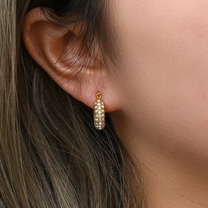 Detailed close-up of 18K gold-plated U-shaped earrings with sparkling cubic zirconia pavé