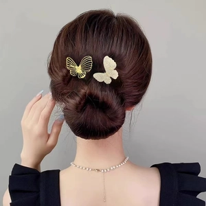 Détail de pinces à cheveux papillon en or évidé et argent avec zircons sur chignon