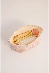 Detail of pink floral lace makeup bag showing spacious interior with zipper closure