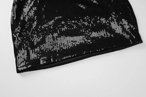 Vue macro du tissu noir avec paillettes argentées sur l'ourlet avec coutures détaillées
