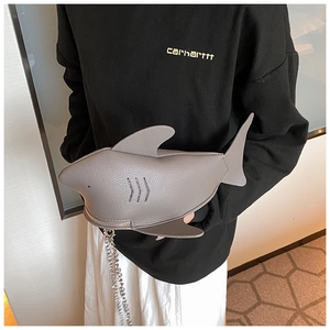 Detail of shark-shaped grey crossbody bag with litchi texture and silver chain strap