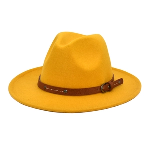 Detailed view of yellow wool fedora hat with brown leather band and metallic rivets