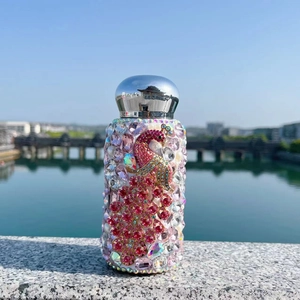 Detailed view of a 304 stainless steel tumbler with handmade peacock rhinestone patterns