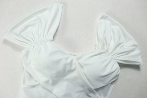 Detail shot of the pleated off-shoulder neckline on a white elegant V-neck dress
